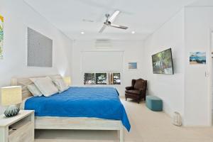 a bedroom with a bed and a ceiling fan at Belle Escapes 60 Ocean Palm Cove in Palm Cove +21 photos