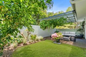 a garden with a patio and a lawn at Belle Escapes 60 Ocean Palm Cove in Palm Cove