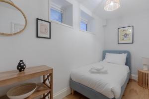 - une petite chambre avec un lit et un miroir dans l'établissement Newly Refurbished 2BD Flat - Wimbledon Village!, à Londres