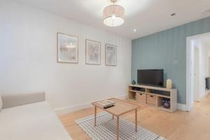 - un salon avec un canapé et une télévision dans l'établissement Newly Refurbished 2BD Flat - Wimbledon Village!, à Londres