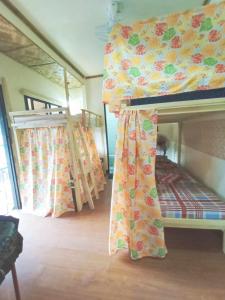 1 dormitorio con 2 literas y ventana en El Gordo's Seaside Adventure Lodge, en El Nido