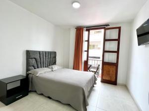 - une chambre avec un lit, une télévision et une fenêtre dans l'établissement Hotel Dorado Real HDR, à Popayan