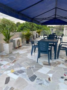 a patio with a table and chairs and an umbrella at Hostel ISABELLA in Santa Marta