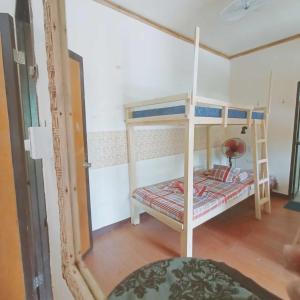 a small bedroom with bunk beds and a mirror at El Gordo's Seaside Adventure Lodge in El Nido