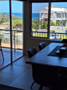 a dining room with a table and a view of the ocean at Pandanus Coolum Beach in Coolum Beach