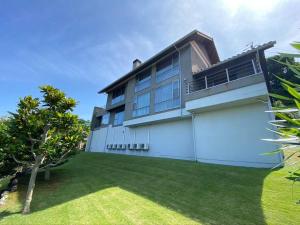 an exterior view of a house with a yard at Ocean View Luxury Beach House - Enjoy Spring Cherry Blossoms, Beaches and BBQ at a Luxury Home in Shimoda