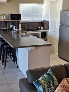 a kitchen with a sink and a counter top at Pandanus Coolum Beach in Coolum Beach