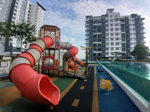 um parque infantil com um escorrega junto a uma piscina em New Vacation Homestay @Forest Valley em Kajang