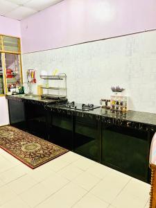 een keuken met een zwart aanrecht in een kamer bij Danisha Homestay in Kampong Baru