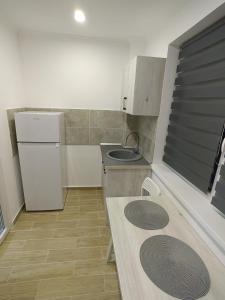 a small kitchen with a sink and a refrigerator at Militari Luxury Flat in Roşu