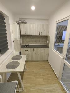 una cocina con armarios de madera y una mesa. en Militari Luxury Flat en Roşu