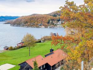 a house on a hill next to a body of water at 8 person holiday home in Tau-By Traum in Tau