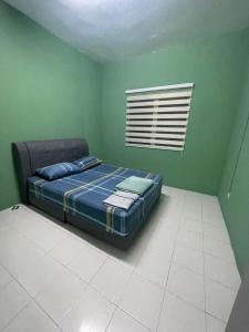 a bedroom with a bed in a green room at Alfaruqi Homestay Seaview in Beserah