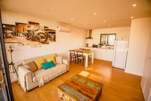 Una sala de estar con un sofá y una mesa y una cocina. en Deluxe Private Pool Bungalow, en Celorico de Basto