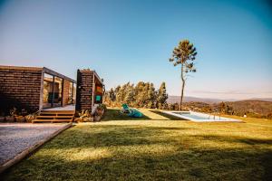una casa con un gran patio con parque infantil en Deluxe Private Pool Bungalow, en Celorico de Basto