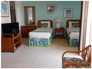 a hotel room with two beds and a television at Hawaiian Hospitality in Honolulu