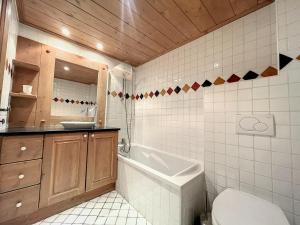 uma casa de banho com uma banheira, um WC e um lavatório. em Appartement Chamonix-Mont-Blanc, 3 pièces, 6 personnes - FR-1-507-76 em Chamonix-Mont-Blanc