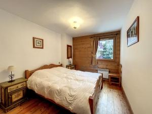 um quarto com uma cama e uma janela em Appartement Chamonix-Mont-Blanc, 3 pièces, 6 personnes - FR-1-507-76 em Chamonix-Mont-Blanc