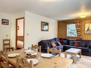 uma sala de estar com uma mesa e um sofá azul em Appartement Chamonix-Mont-Blanc, 3 pièces, 6 personnes - FR-1-507-76 em Chamonix-Mont-Blanc