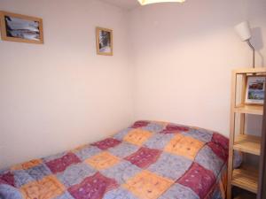 シャンルッスにあるStudio cabine à Chamrousse, RDC, balcon nord, au pied des pistes, bien équipé - FR-1-340-274のベッドルーム(カラフルなキルトのベッド付)