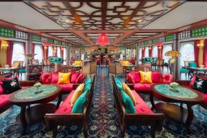 a train car with couches and tables in a room at Indochine Premium Halong Bay Powered by Aston in Ha Long
