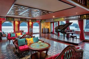 Indochine Premium Halong Bay Powered by Aston في ها لونغ: غرفة معيشة فيها بيانو وطاولة