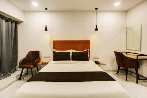 海得拉巴的住宿－Rcc Hotel Banjara Hills，卧室配有一张床和一张桌子及椅子