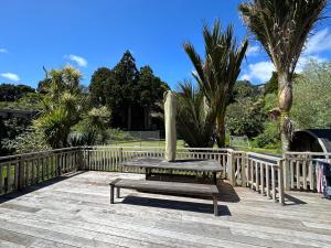 a bench sitting on top of a wooden deck at Nikau Retreat in New Plymouth