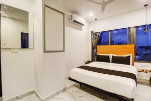 a bedroom with a bed and a window at Rcc Hotel Banjara Hills in Hyderabad