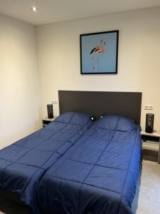 a bed with a blue comforter in a bedroom at Enkhuizer Strand Chalet Strandmuschel Erste Reihe Hausnr 215 in Enkhuizen