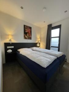 a bedroom with a large bed in a room at Enkhuizer Strand Chalet Beach Oase Erste Reihe mit Zaun Haus Nr 248 in Enkhuizen