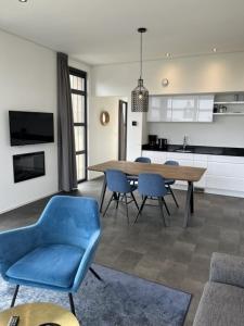 een woonkamer met een tafel en stoelen en een keuken bij Enkhuizer Strand Chalet Meeresbrise Dritte Reihe mit Zaun Haus Nr 251 in Enkhuizen