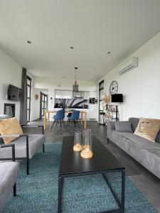 ein Wohnzimmer mit einem Sofa und einem Tisch in der Unterkunft Enkhuizer Strand Chalet Sunkiss Dritte Reihe Haus Nr 217 in Enkhuizen
