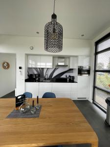 una cucina con un tavolo di legno e una sala da pranzo di Enkhuizer Strand Chalet Sunkiss Dritte Reihe Haus Nr 217 a Enkhuizen