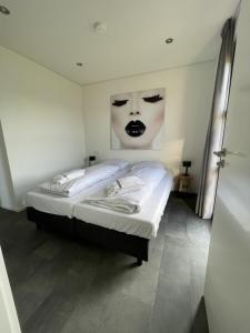 ein Schlafzimmer mit einem Bett mit einem Gesicht an der Wand in der Unterkunft Enkhuizer Strand Chalet Sunkiss Dritte Reihe Haus Nr 217 in Enkhuizen