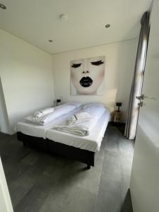 una camera da letto con un letto e un viso sul muro di Enkhuizer Strand Chalet Sunkiss Dritte Reihe Haus Nr 217 a Enkhuizen