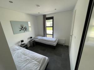 1 dormitorio con 2 camas y ventana en Enkhuizer Strand Chalet MeerZeit Dritte Reihe Haus Nr 212, en Enkhuizen