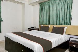 a bedroom with a large bed with a green curtain at Hotel Seven Hills in Dāpuri