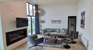 a living room with a couch and a fireplace at Enkhuizer Strand Cube Elite Estel mit Dachterrasse und Zaun Haus Nr 337 in Enkhuizen