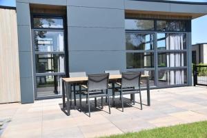 a wooden table and chairs in front of a building at Enkhuizer Strand Chalet Sonnenblume Vierte Reihe mit Zaun Haus Nr 234 in Enkhuizen