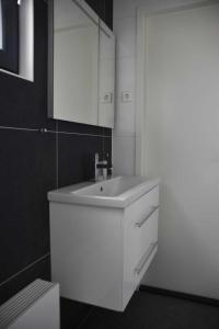 ein Badezimmer mit einem weißen Waschbecken und einem Spiegel in der Unterkunft Enkhuizer Strand Chalet Sonnenblume Vierte Reihe mit Zaun Haus Nr 234 in Enkhuizen