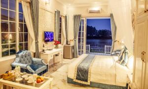 1 dormitorio con cama y ventana con vistas en Vườn Vua Resort & Spa -by Bay Luxury, en Ðồng Phú