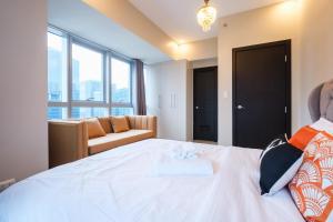 Ένα ή περισσότερα κρεβάτια σε δωμάτιο στο Spacious 2BR Apartment in BGC with Workspace & Washer