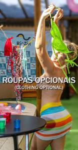 una mujer con un traje de baño rayado sosteniendo una hoja en RioZin Pousada Liberal - Somente Adultos - Clothing Optional - Lifestyle Hotel en Río de Janeiro