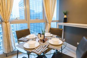 a dining room with a table and chairs and a large window at Spacious 2BR Apartment in BGC with Workspace & Washer in Manila
