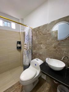 a bathroom with a white toilet and a sink at Habitaciones y aptos Isabella in Santa Marta
