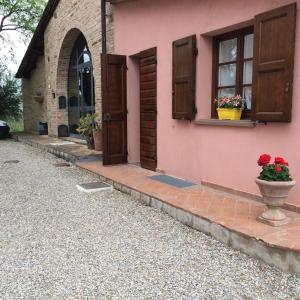 a pink house with a window and a vase of flowers at Casina Rosa in Certaldo