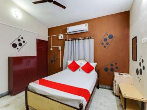 a bedroom with a bed with red pillows on it at Vsv Guest House Maduravoyal in Chennai