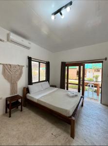 ein Schlafzimmer mit einem großen Bett und einem Fenster in der Unterkunft Casa De Loren in General Luna