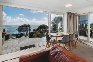 Sala de estar con mesa y vistas al océano en Te Moana Waterfront, en New Plymouth